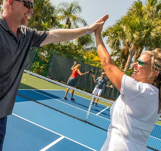 Couples on pickleball courts at Orchid Island