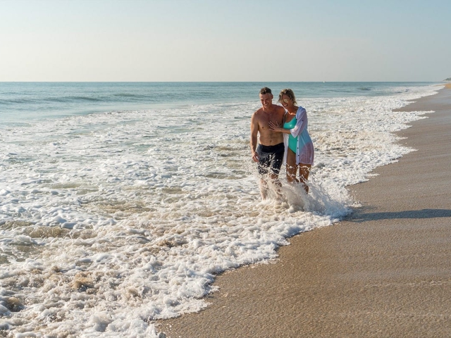 Couple walking in the water along the shores of Vero Beach Florida