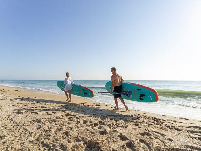 Couple walking with Surfboards along the shores of Vero Beach