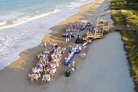Orchid Island Members gather on the beach for a member-only cookout event.
