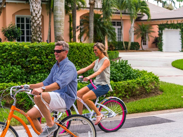 Couple riding bicycle through the streets at Orchid Island Vero Beach