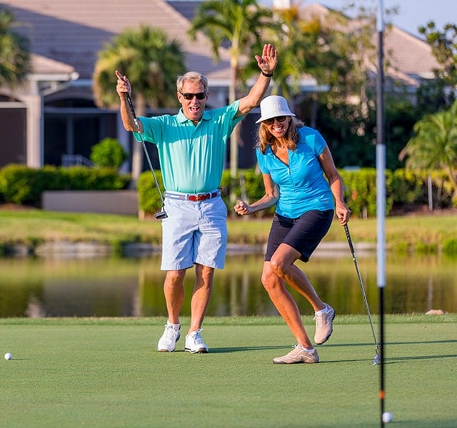 A couple on the putting green at Orchid Island Golf Club, celebrating a good putt.