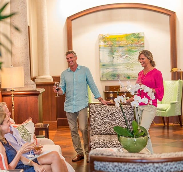 Interior shot of two couples drinking wine and enjoying the Orchid Island Beach Club Clubhouse