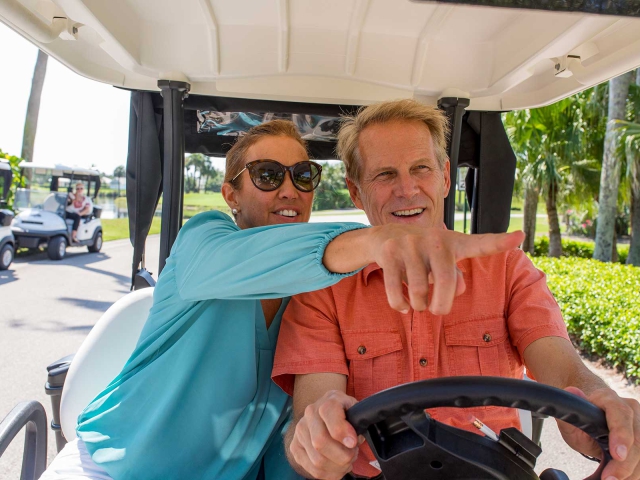 Couple in golf cart outside of Orchid Island Golf Clubhouse