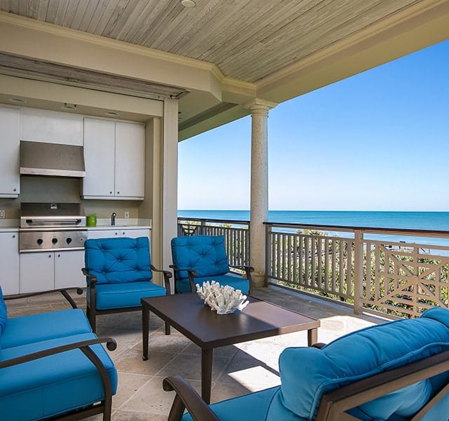 Patio with blue cushioned chairs at Orchid Island Oceanfront Condos
