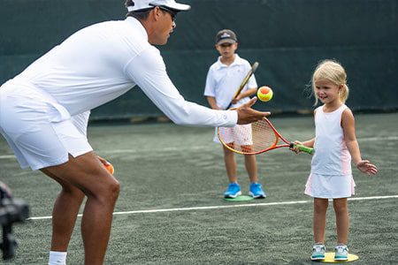 tennis instructor with kid at orchid island