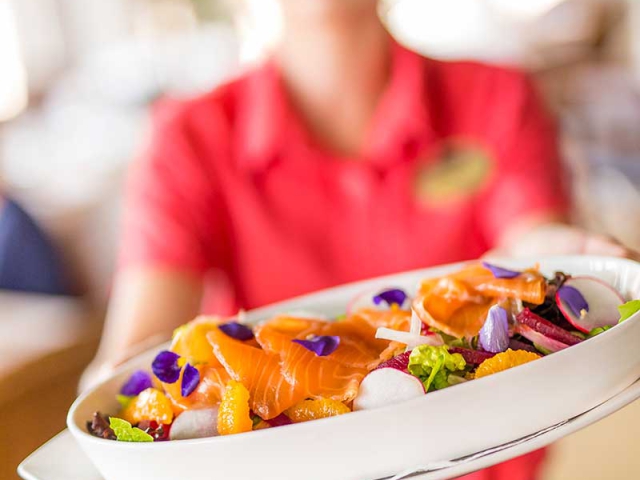 Woman showing a Seafood Plate at Orchid Island Golf and Beach Club