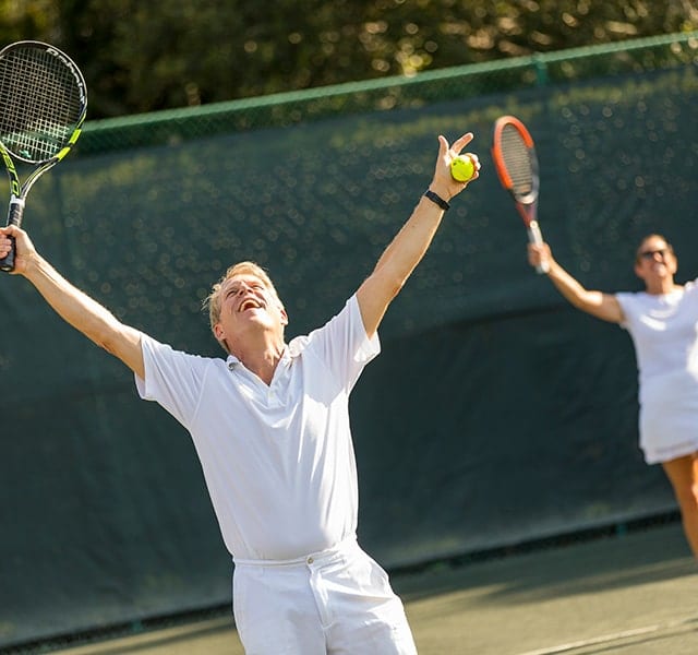 Couple raise arms in celebration of a Tennis win at Orchid Island Tennis Club