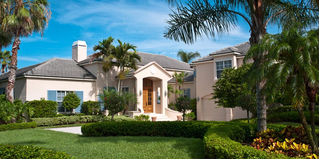 Exterior of a pink home with blue shutters at Orchid Island in Vero Beach