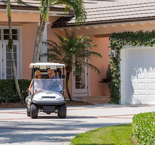 Couple driving around Orchid Island in golf cart enjoying the golf club lifestyle
