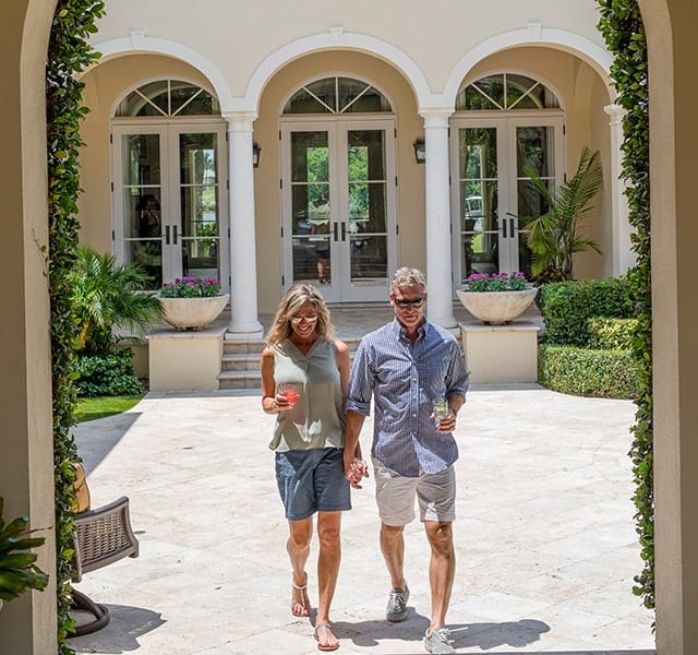 Couple holding hands, walking towards an entrance at Orchid Island in Vero Beach