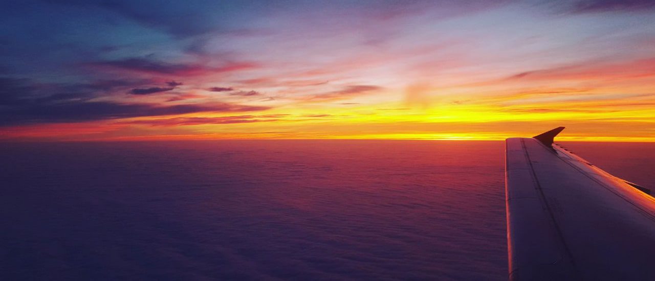airplane wing and sunset on horizon over florida
