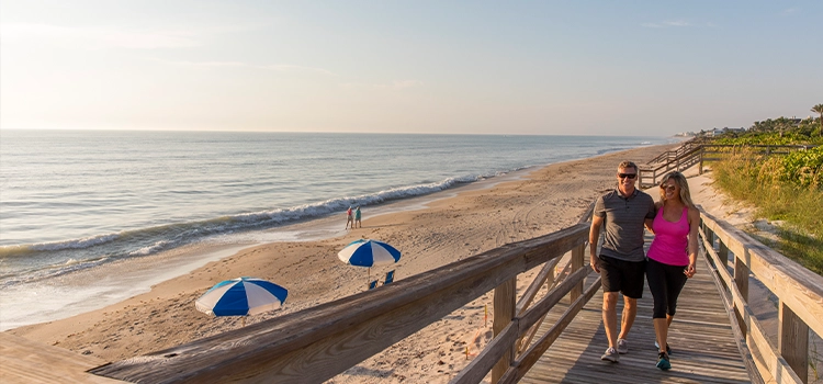 Couple walking along Orchid Island’s private beach boardwalk