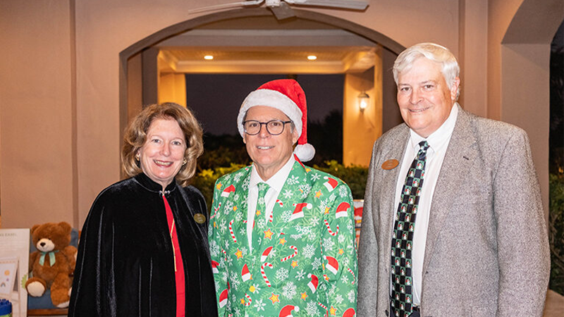Orchid Island holiday charity event, one wearing a green Christmas suit and Santa hat.