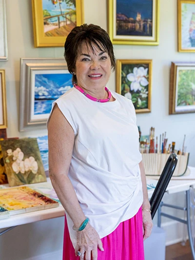 Orchid Island Member Ruth Martin standing in front of art